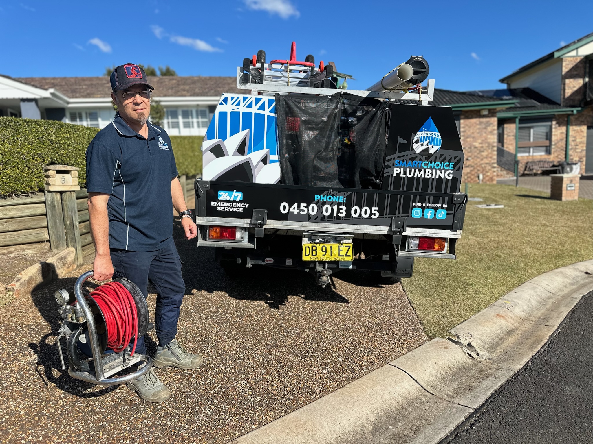 Smart Choice Plumbing plumber with a high-pressure water jetter beside the branded service truck in Campbelltown
