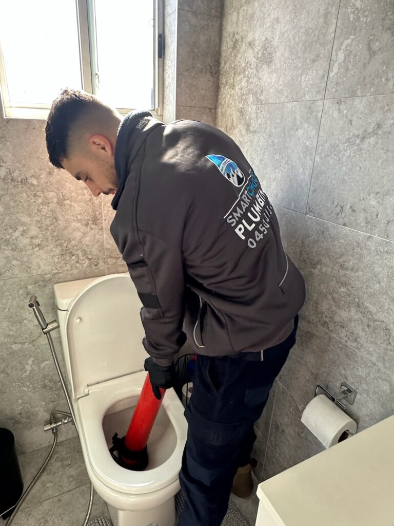 Smart Choice Plumbing plumber clearing a blocked toilet